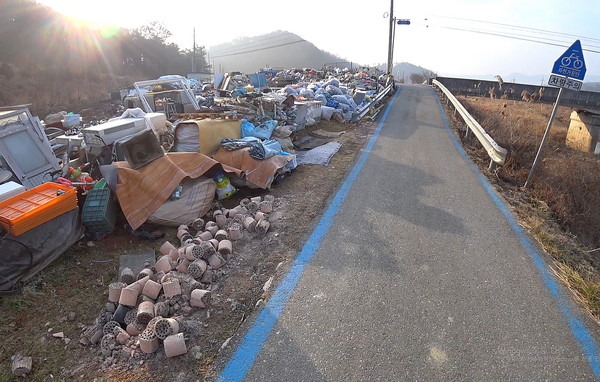 고물과 연탄재가 쌓여 쓰레기장을 방불케 하는 곳. 울타리도 없이 자전거길에 접해 있다(순창 신남리)