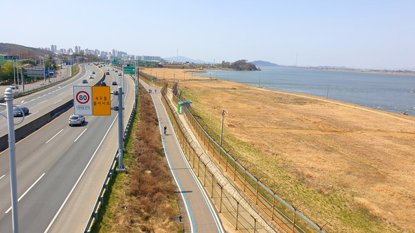 일산대교 남단에서 하류 방면으로 본 김포한강로와 평화누리 자전거길. 멀리 김포 한강신도시가 보인다 
